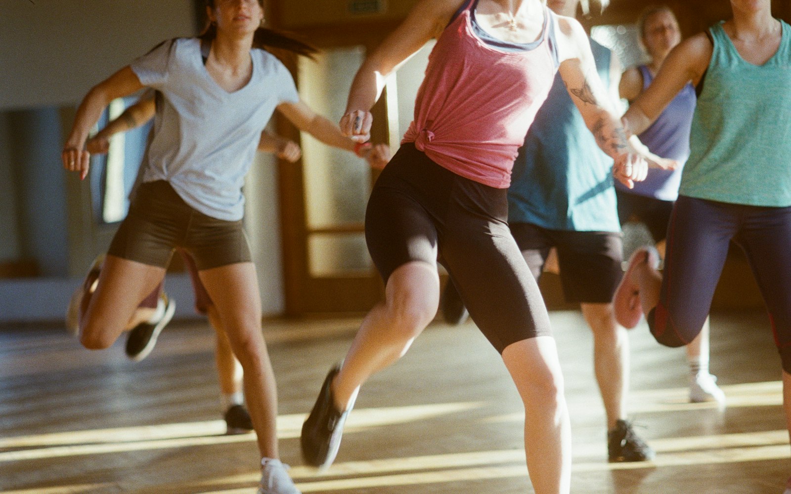 Group of women running together in a bright studio class
