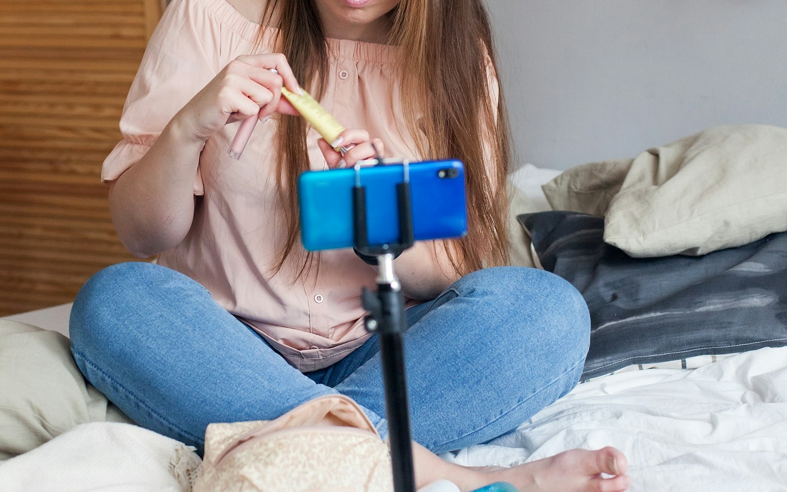 Woman filming a product on a phone mounted on a tripod
