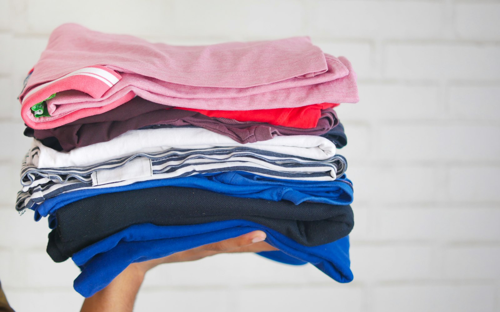 Stack of folded workout clothes held in two hands